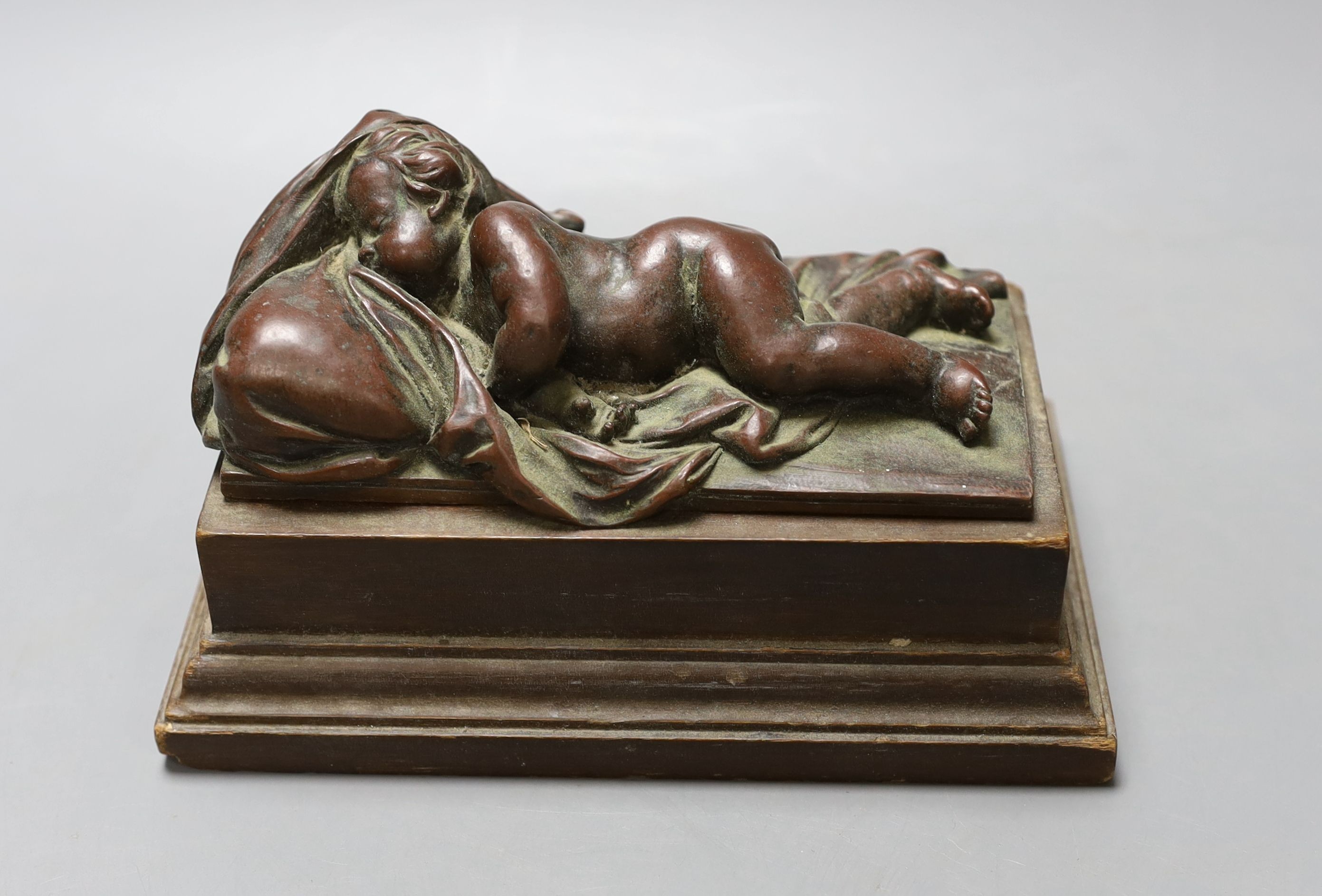 An electrotype figure of a recumbent putti on wooden base